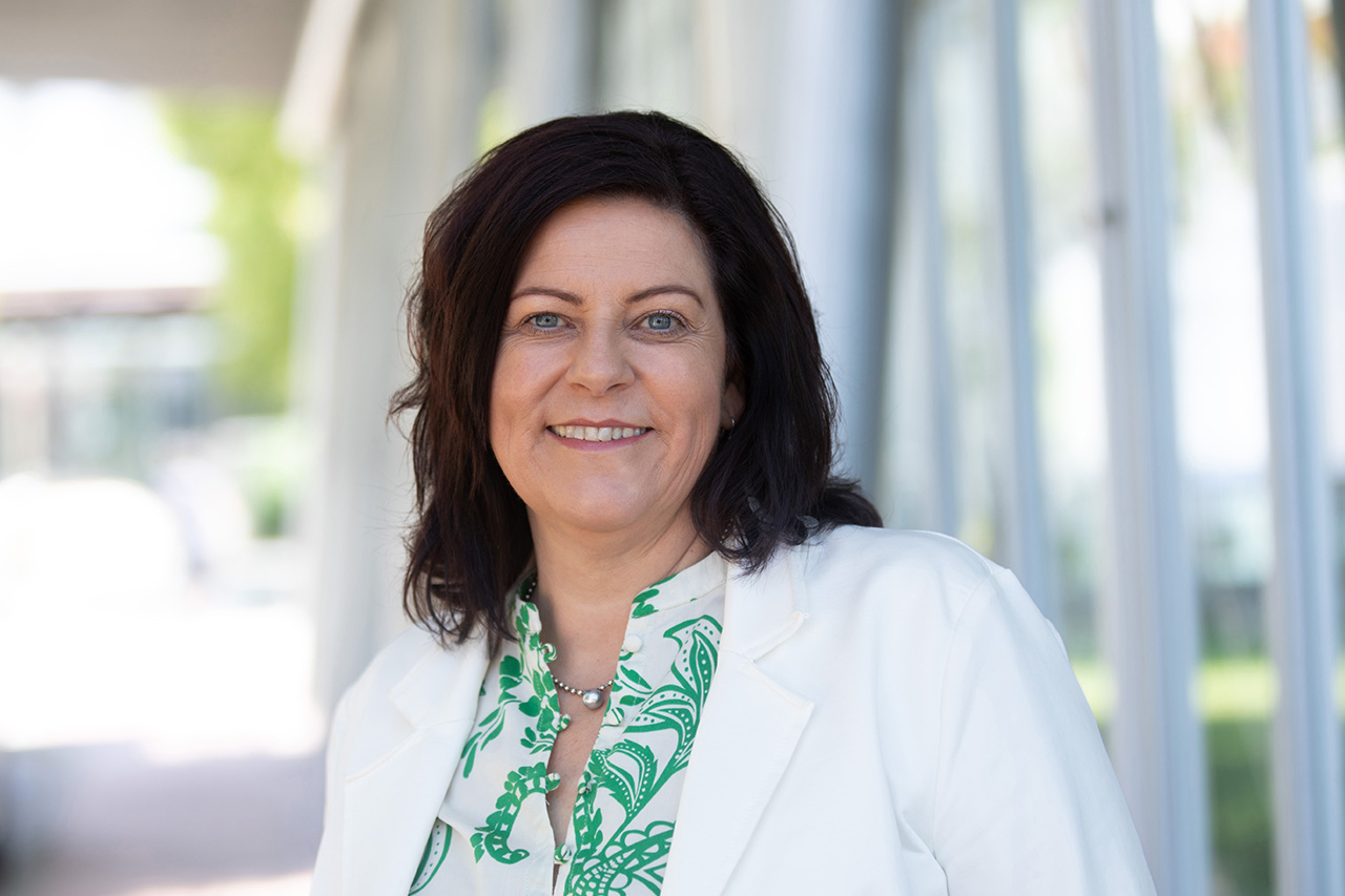 Portrait von Claudia Waldmann vor sonnigem, städtischem Hintergrund (Foto: © photoprisma)